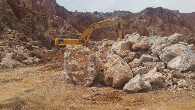 挖掘機(jī)正在開采山上的石頭